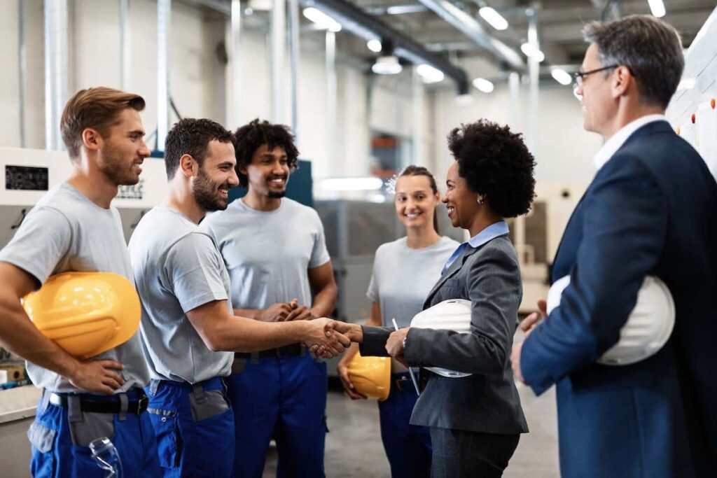 group of people at the factory greeting employees